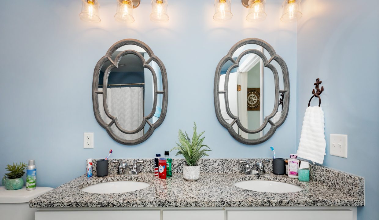 a bathroom with two sinks and two mirrors.