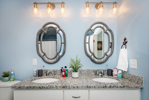 a bathroom with two sinks and two mirrors.