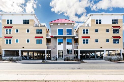 a two story apartment building with a red roof.