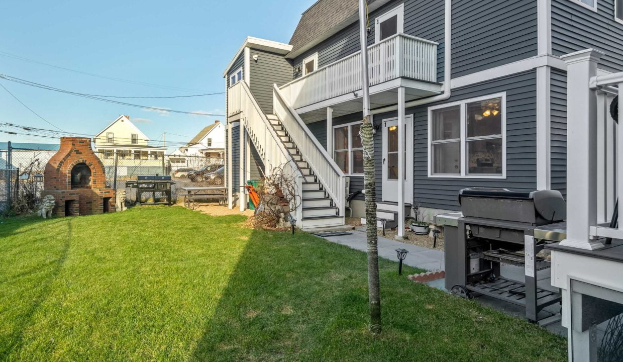 a house with a grill in the yard.