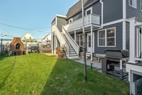 a house with a grill in the yard.