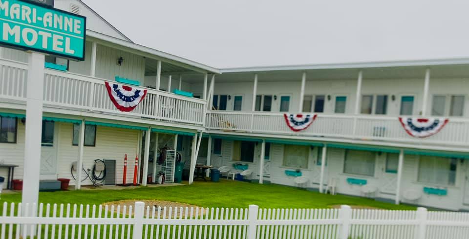 a motel with a white picket fence in front of it.