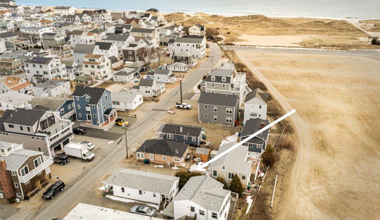 an aerial view of a town with a beach in the background.