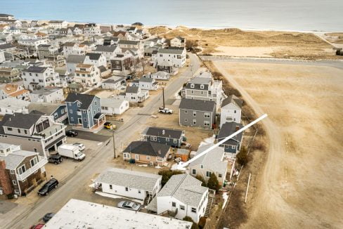 an aerial view of a town with a beach in the background.