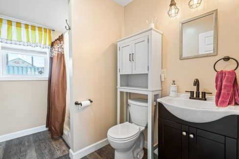 a bathroom with a toilet, sink, and mirror.