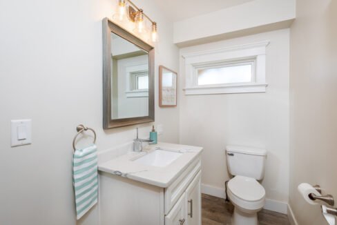 a bathroom with a sink, toilet, and mirror.