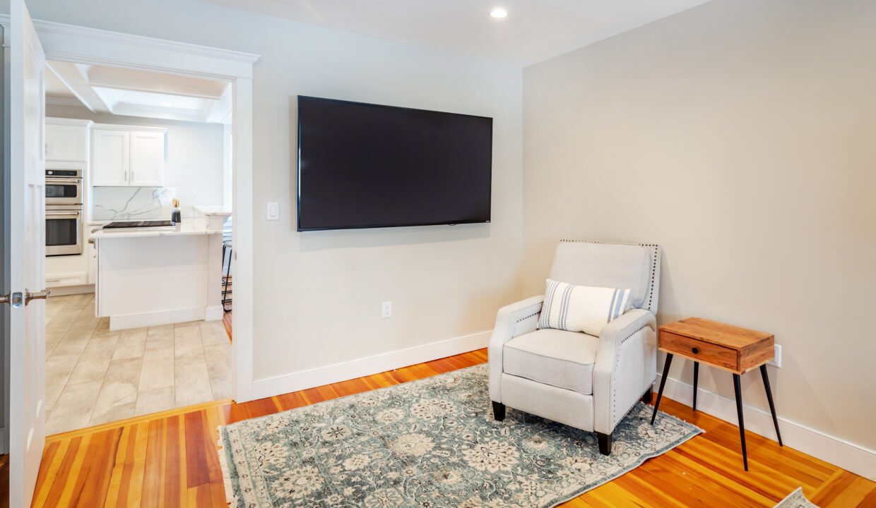 a living room with a chair and a flat screen tv.