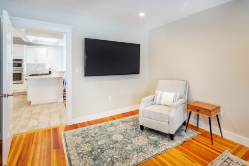 a living room with a chair and a flat screen tv.