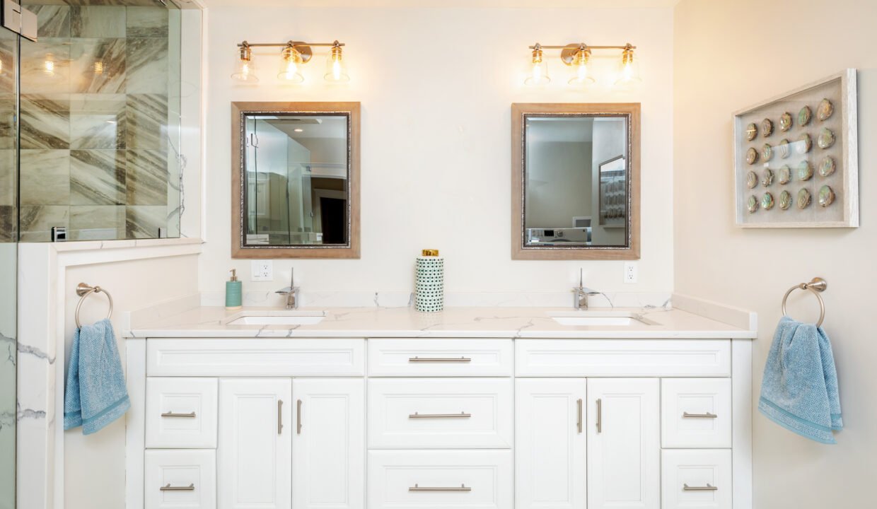 a bathroom with two sinks and two mirrors.