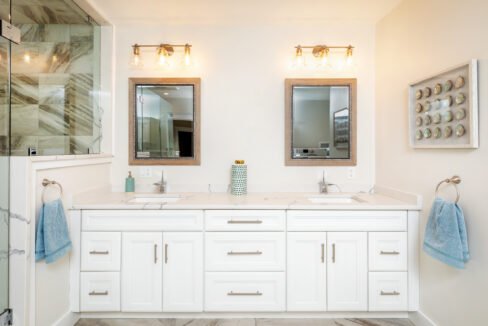 a bathroom with two sinks and two mirrors.