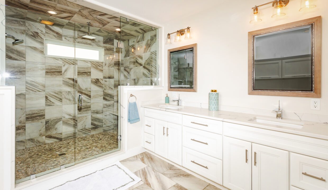 a bathroom with a walk in shower next to a sink.