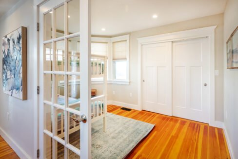 a room with a wooden floor and a white door.