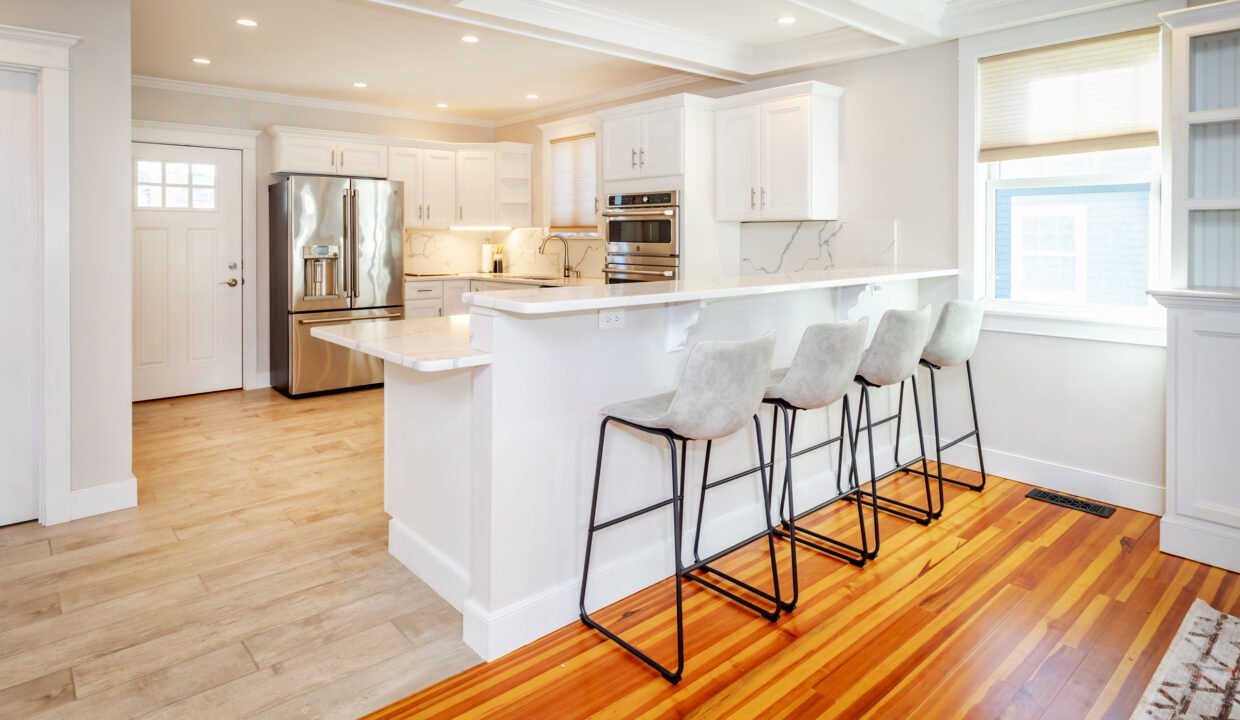 a kitchen with a center island with four bar stools.