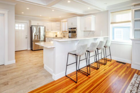 a kitchen with a center island with four bar stools.