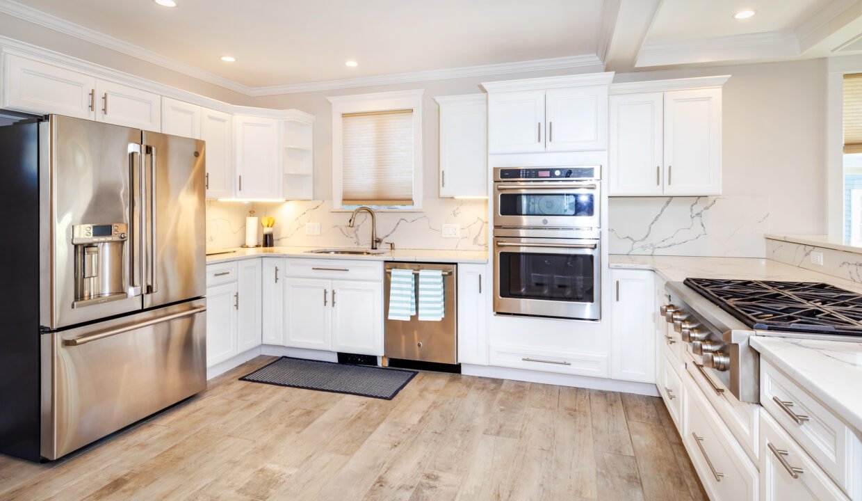 a kitchen with white cabinets and stainless steel appliances.