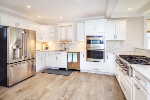 a kitchen with white cabinets and stainless steel appliances.