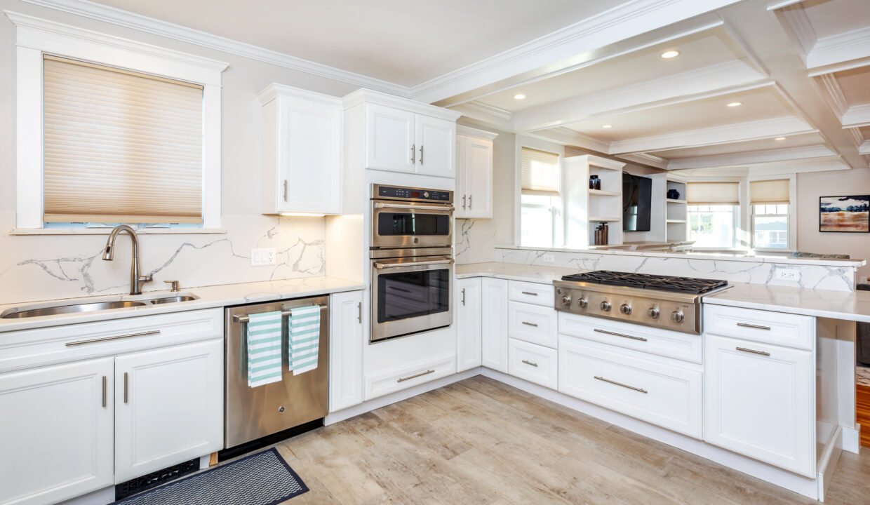 a kitchen with white cabinets and stainless steel appliances.