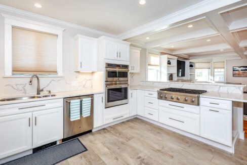 a kitchen with white cabinets and stainless steel appliances.