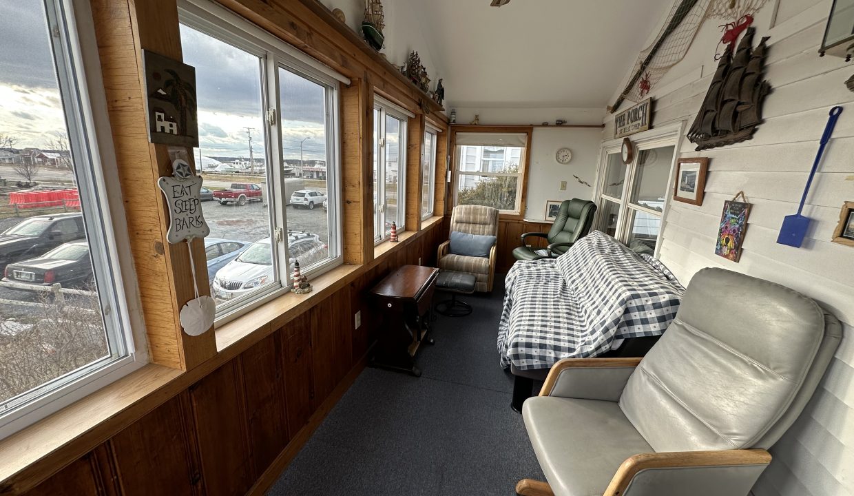 a room with a couch, chair and a window.