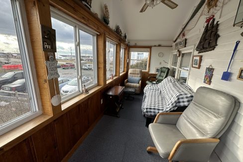 a room with a couch, chair and a window.