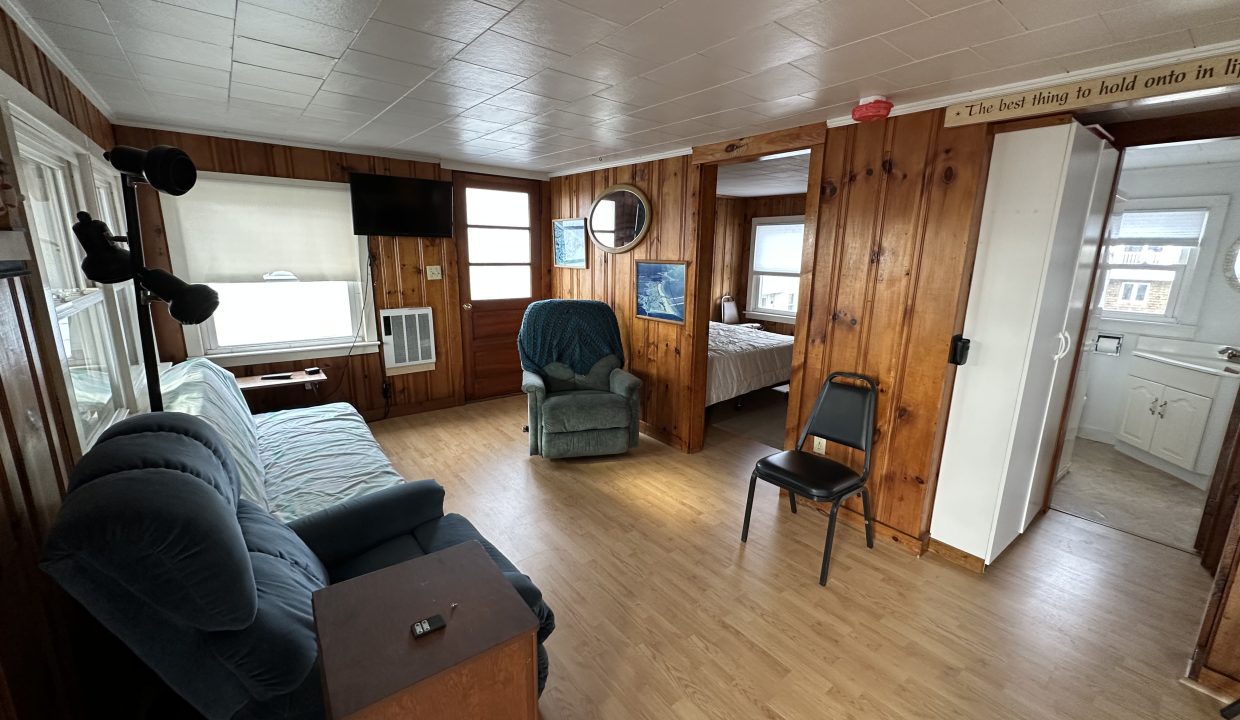 a living room filled with furniture and a hard wood floor.