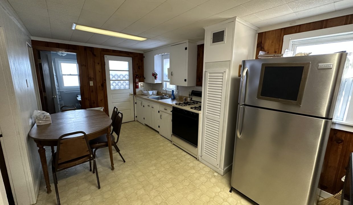 a kitchen with a table and a refrigerator.