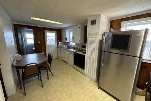 a kitchen with a table and a refrigerator.