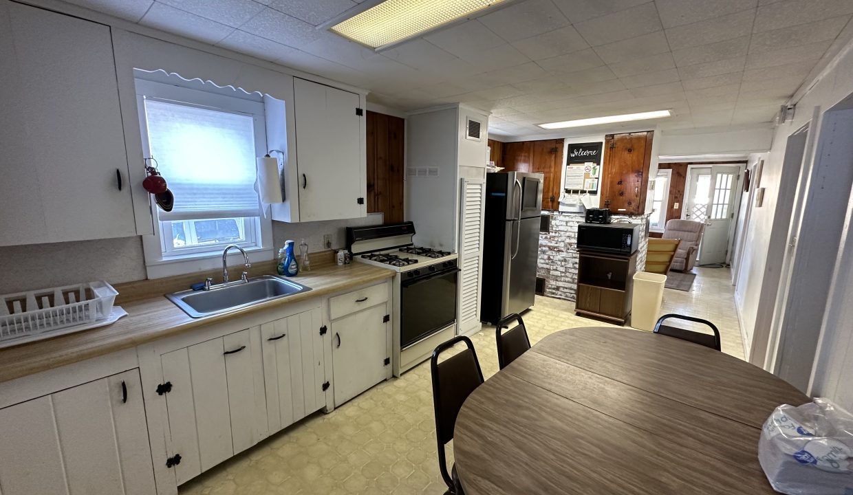 a kitchen with a wooden table and white cabinets.