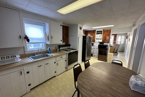 a kitchen with a wooden table and white cabinets.