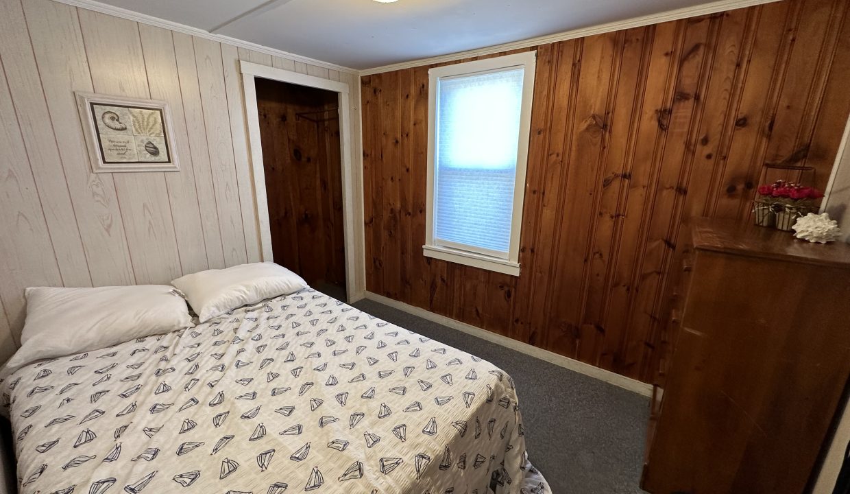 a bedroom with wood paneling and a bed.