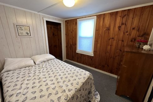 a bedroom with wood paneling and a bed.