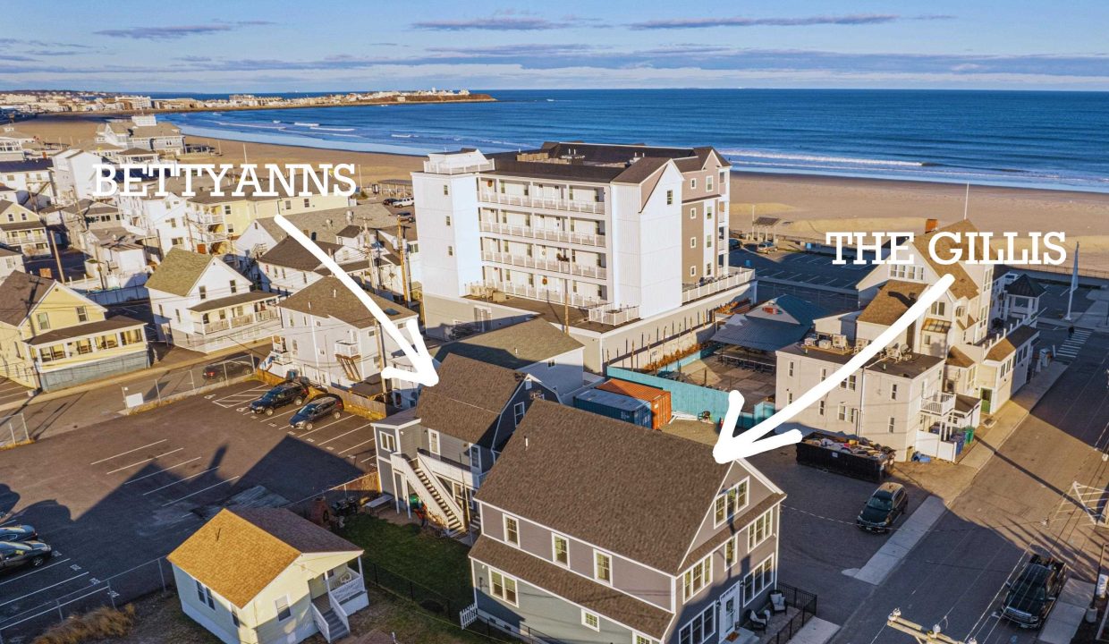 an aerial view of a beach town with the ocean in the background.