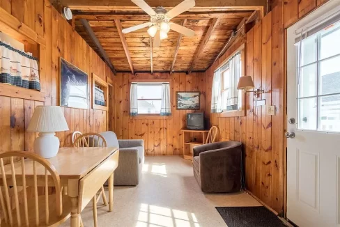 a room with wood paneling and a ceiling fan.