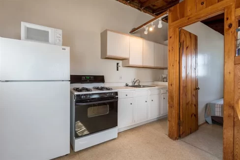 a kitchen with a refrigerator, stove, and microwave.