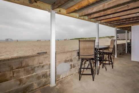 a balcony with a table and chairs overlooking the beach.