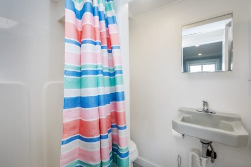 a bathroom with a colorful shower curtain.