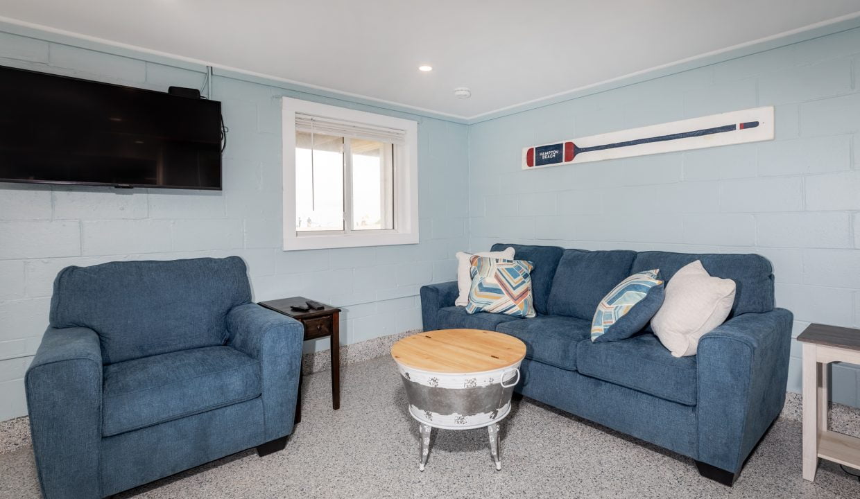 a living room with blue couches and a tv.