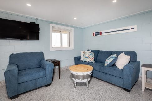 a living room with blue couches and a tv.