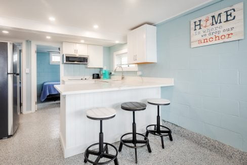 a small kitchen with blue walls and stools.