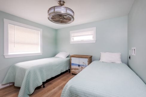 two twin beds in a room with a ceiling fan.