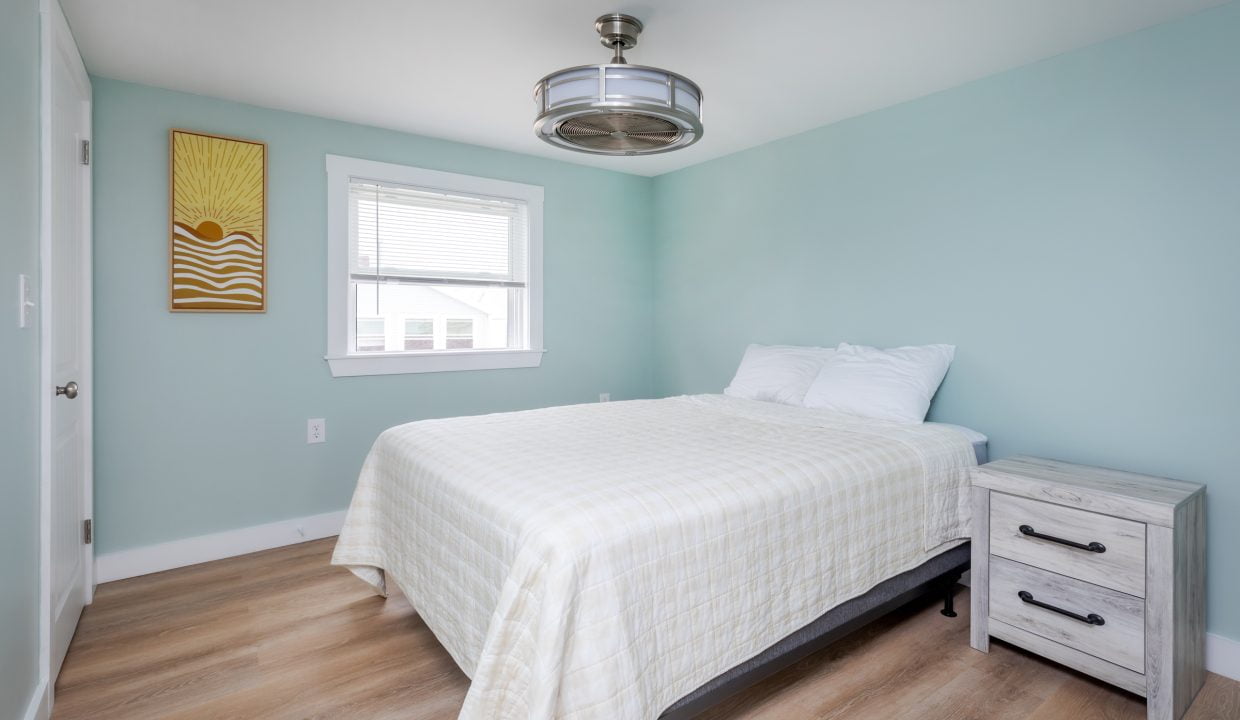 a bedroom with blue walls and a ceiling fan.