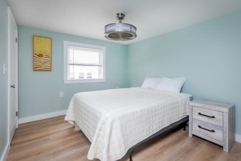 a bedroom with blue walls and a ceiling fan.