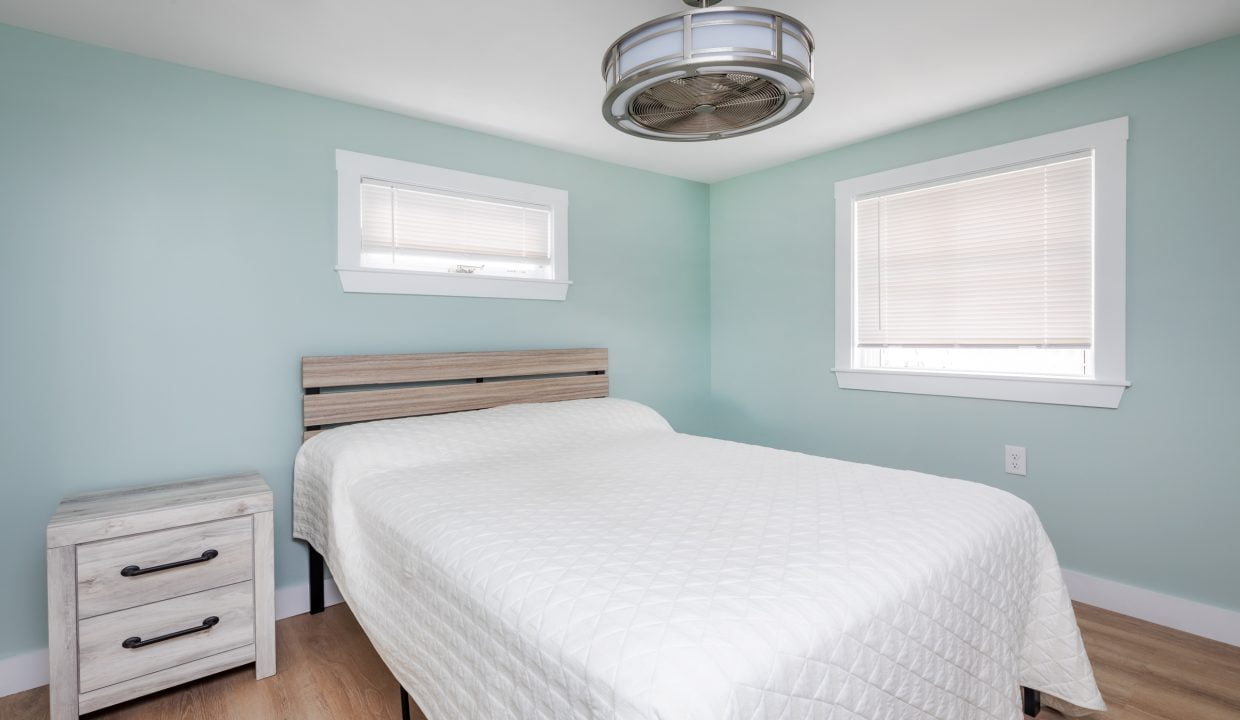 a bedroom with blue walls and a white bed.