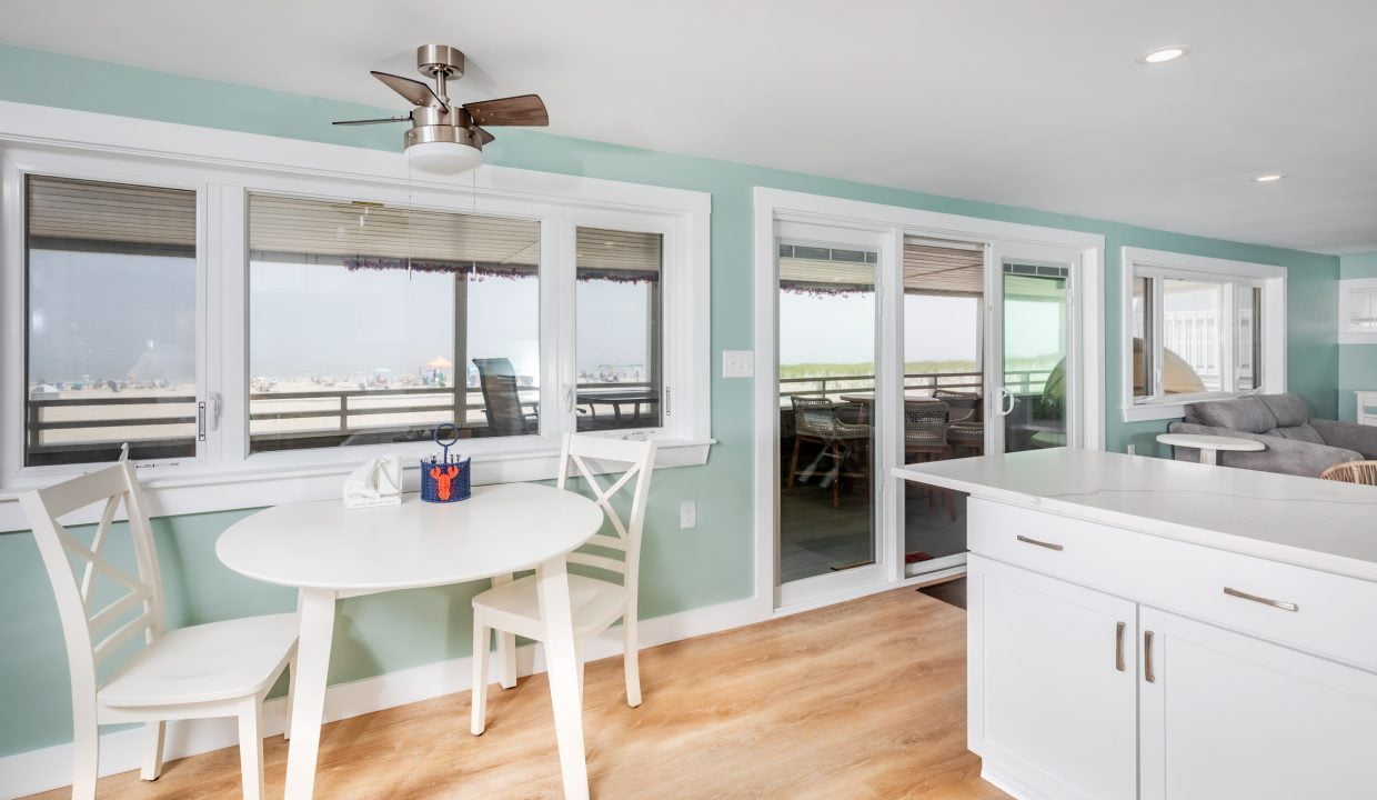 a kitchen with a table and chairs and a view of the ocean.