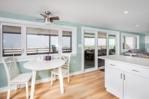 a kitchen with a table and chairs and a view of the ocean.