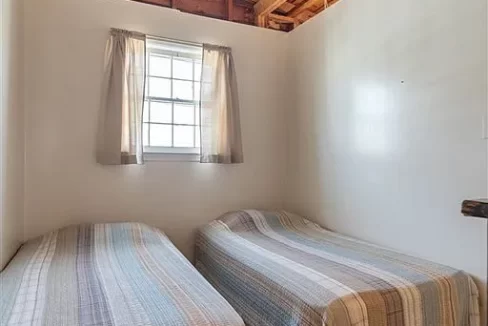 a bedroom with two beds and a window.