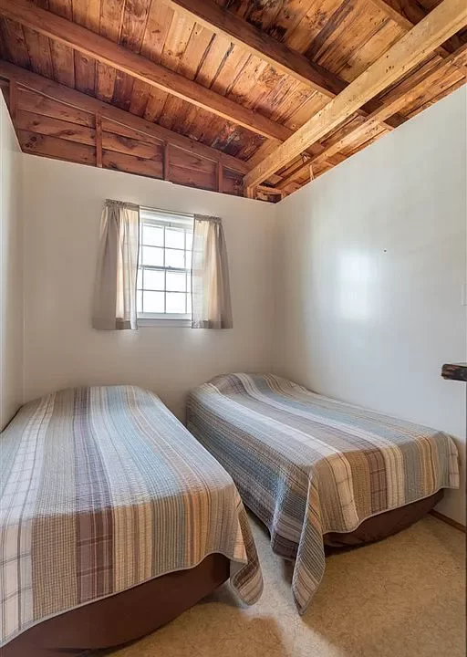 a bedroom with two beds and a window.