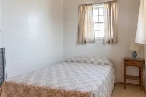 a bed sitting under a wooden ceiling in a bedroom.