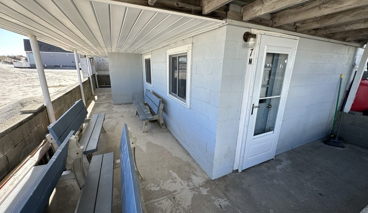 a porch with a bench and a door.