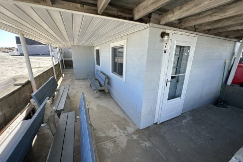 a porch with a bench and a door.